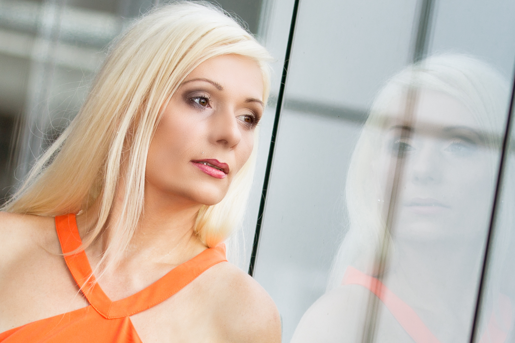 Streetportrait mit blondem Model und Spiegelung in einem Fenster