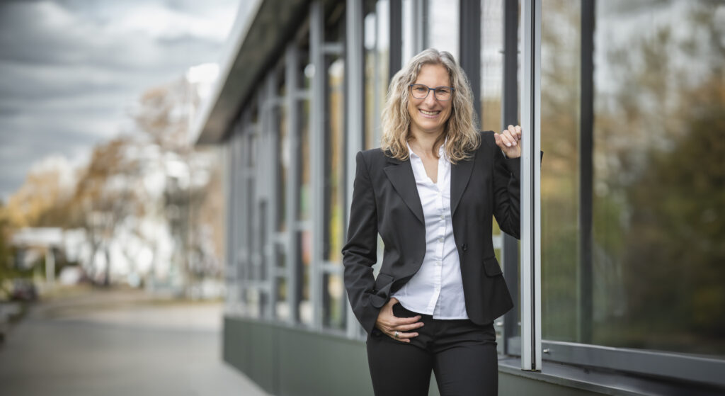 Businessporträt mit Janina mit Blazer und weißer Bluse, hier mit KI erweiterte Variante des Hauptfotos